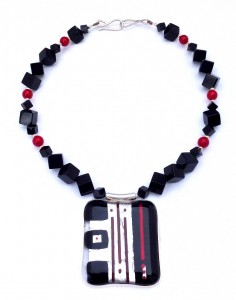 Fused-glass pendant with red lines in a necklace of square beads