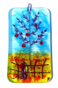 Glass decoration of red apple tree in flowery field with cat on fence
